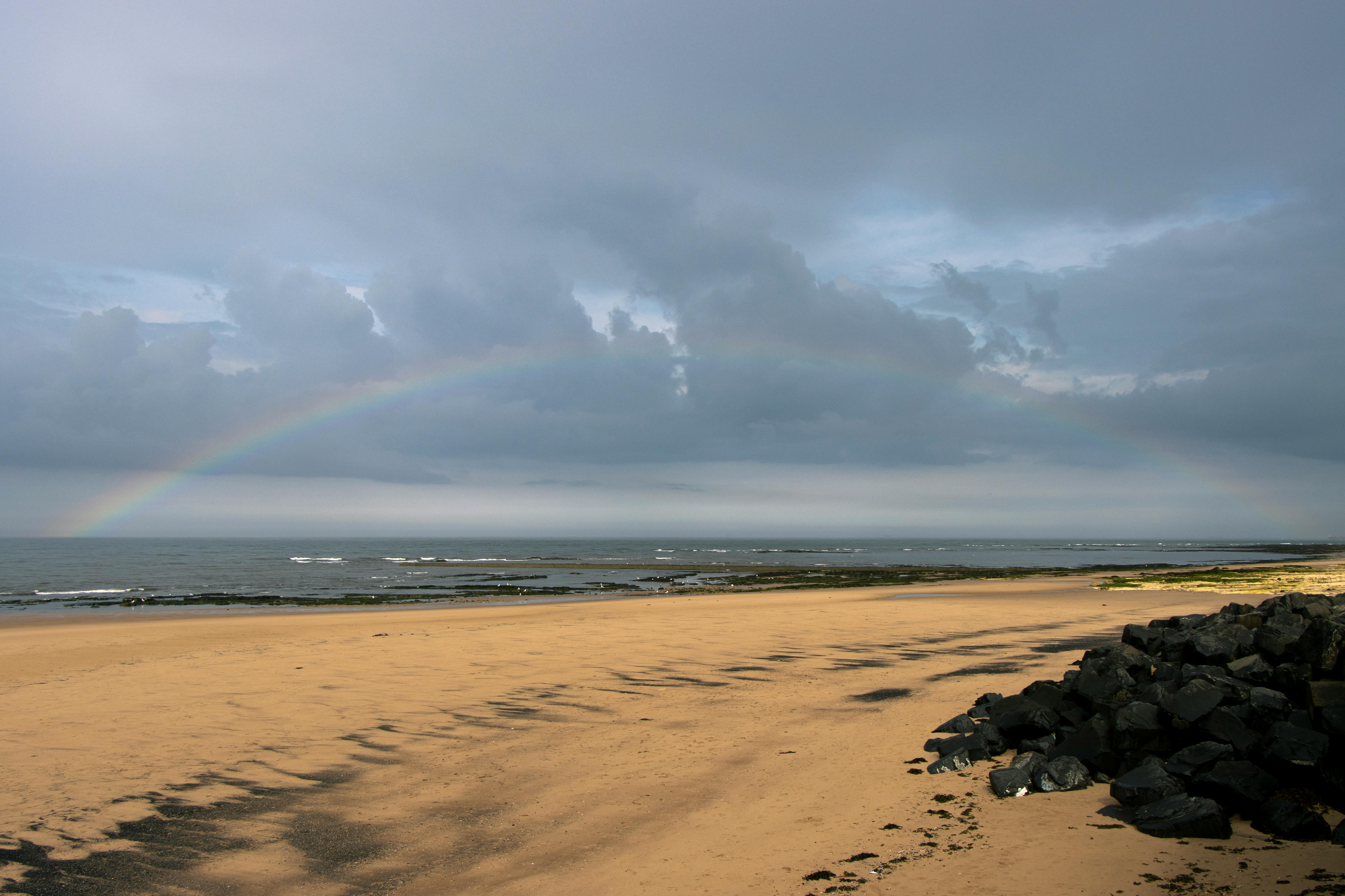Wide sandy beach at Seaham in County Durham on the North East England coast with rainbow over the North Sea